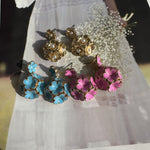 Assorted enamel floral earrings: gold-tone pearl, blue and pink/purple flowers