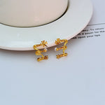 Gold back view of M-shaped logo earrings with hook and clasp details