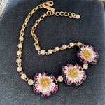 Enamel cherry blossom pendant necklace with white-and-red flowers, gold chain and clear stones