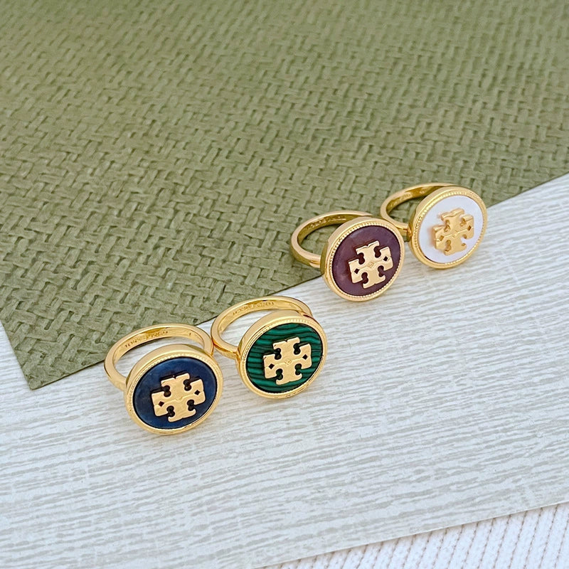 Set of round enamel metal rings: white, green, dark blue, and purple shell centers