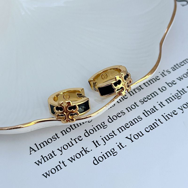 Enamel logo metal earrings with gold-tone hoops and black enamel detailing.