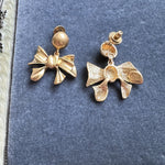 Gold-tone bow drop earrings with textured bow charm and clip backs