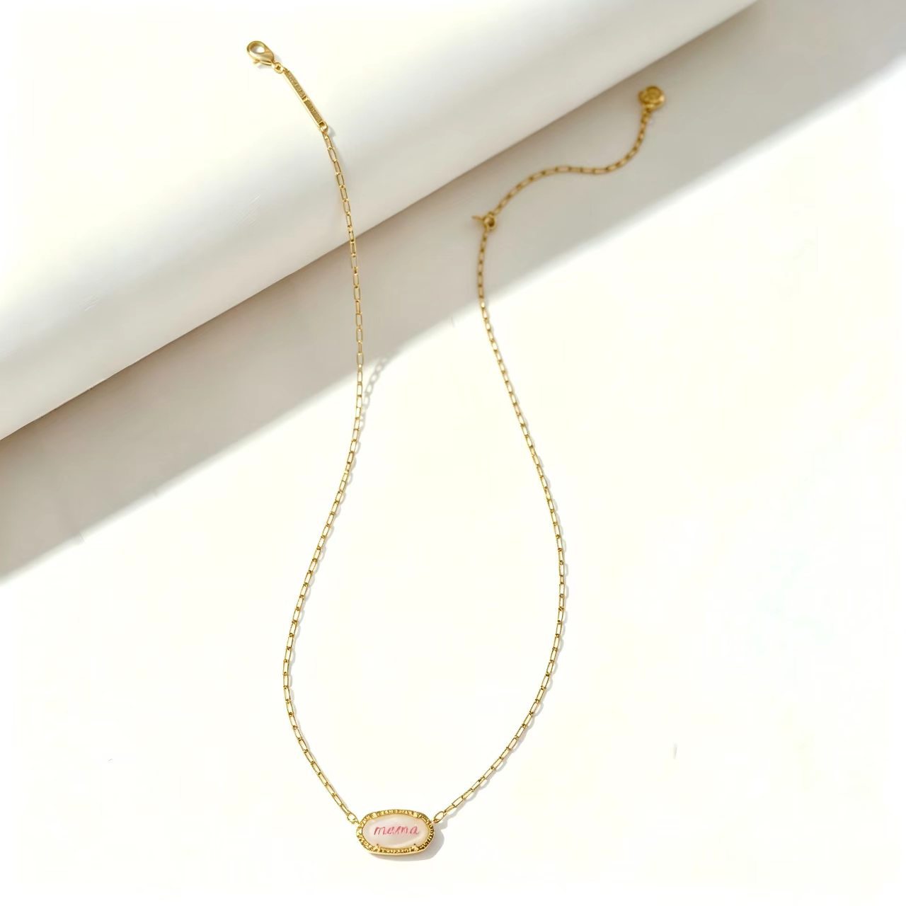 Gold curb-link necklace with oval “mama” pendant charm