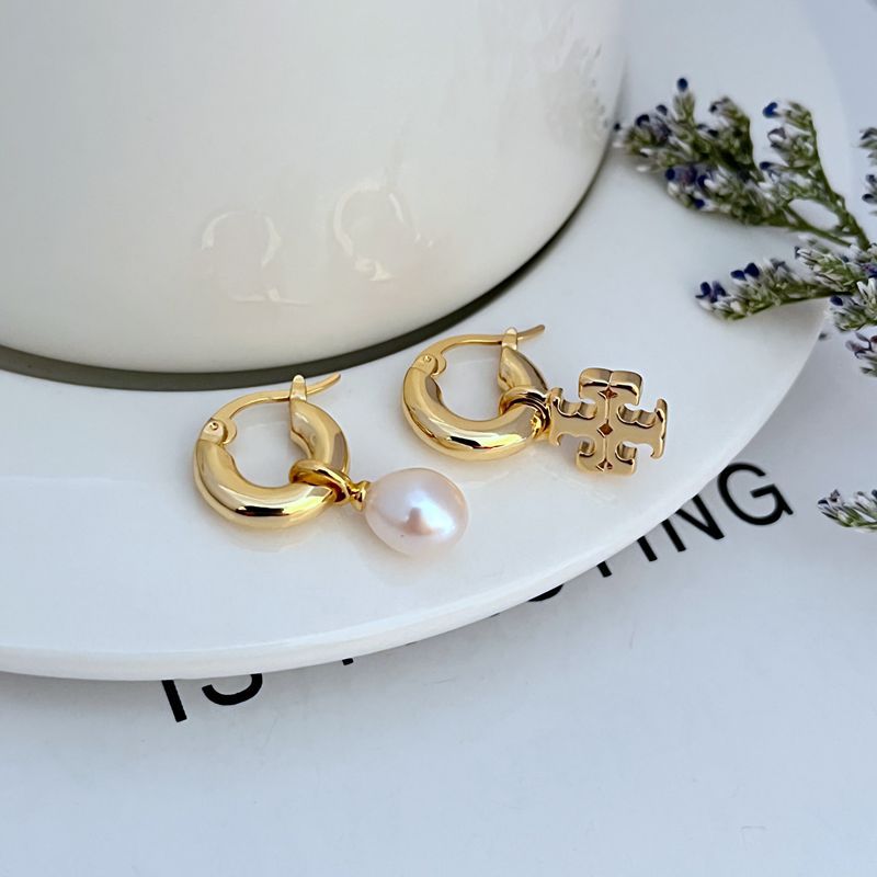 Gold asymmetrical hoop earrings with white pearl drop and ornate charm detail