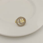Gold-tone round ring with micro-paved outer band and gold filigree star centerpiece.