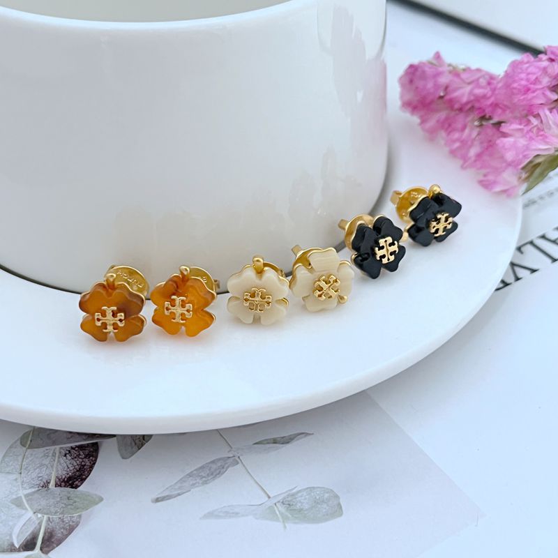 Four-leaf clover stud earrings in amber, white, and black with gold-tone details