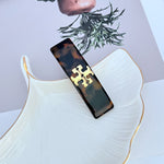 Dark brown acrylic hair clip with gold logo detail
