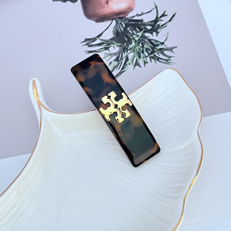 Dark brown acrylic hair clip with gold logo detail