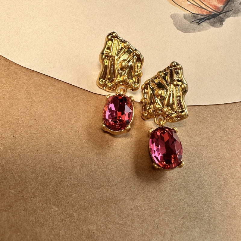 Rose-red crystal drop earrings with gold-tone textured caps