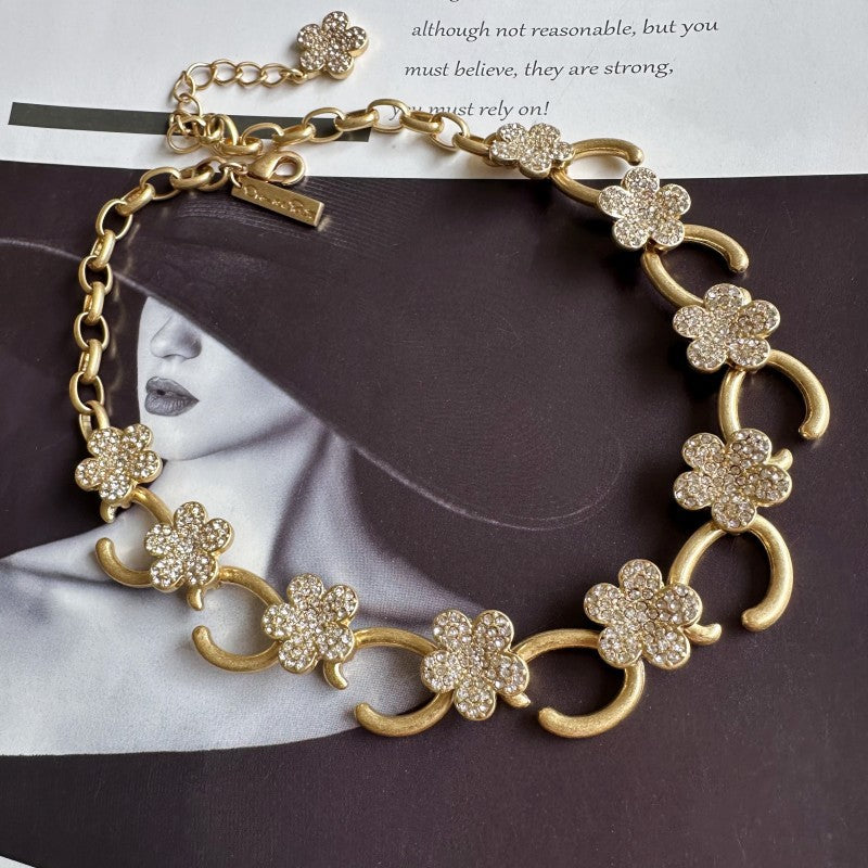 Gold-tone O-ring floral necklace with clear crystal flower charms and link chain