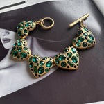 Heart bracelet with green gemstone heart charms and gold-tone chain links