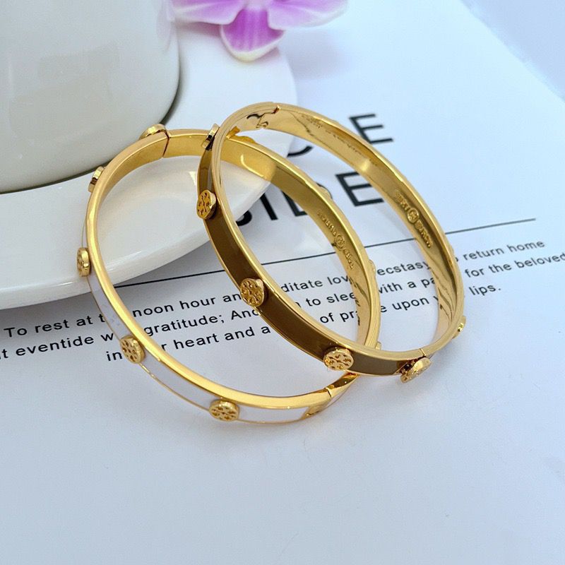 Stacked gold-tone enamel logo bangles, round with raised medallion end caps