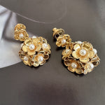 Gold-tone enamel hydrangea stud earrings with pearl-like accents and metal petals