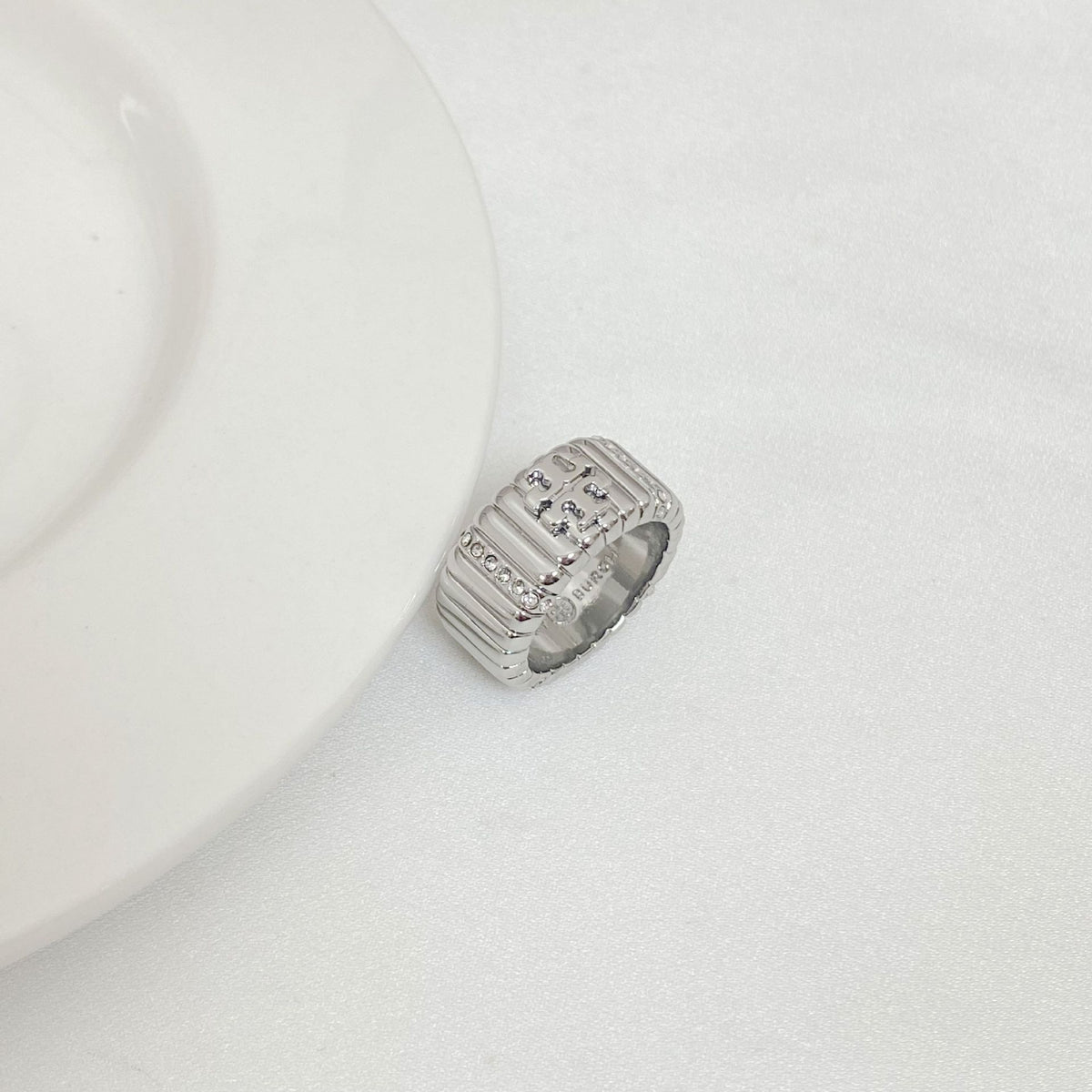 Silver-tone rhinestone letter inlay ring with engraved pattern and raised top