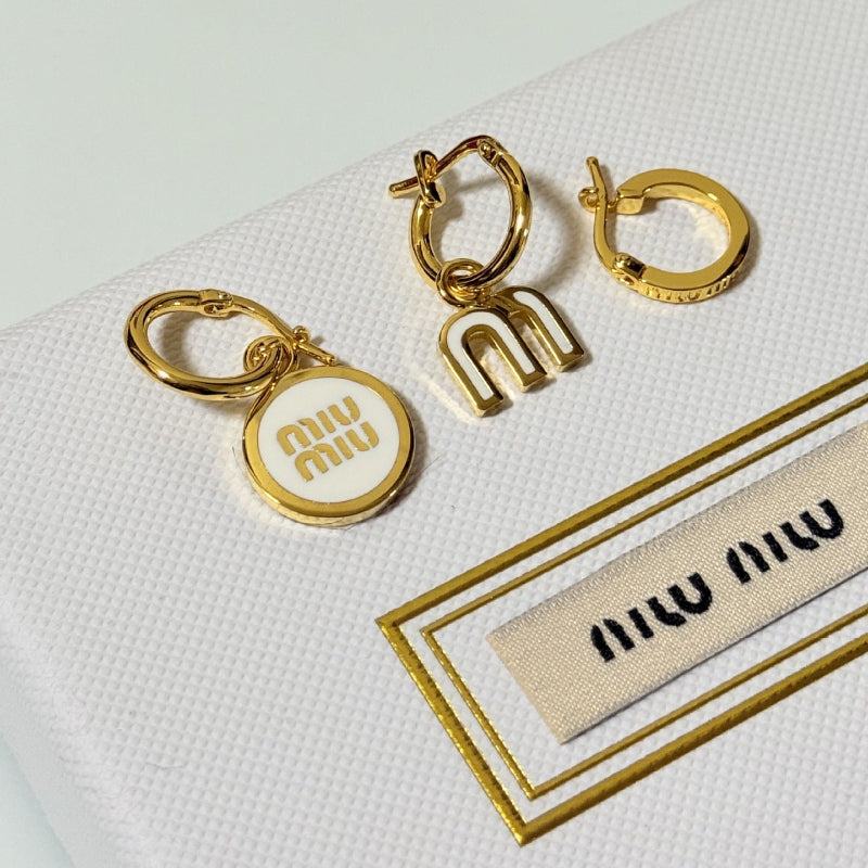 Three-piece enamel hoop earrings with white round charm and gold-tone metal hoops