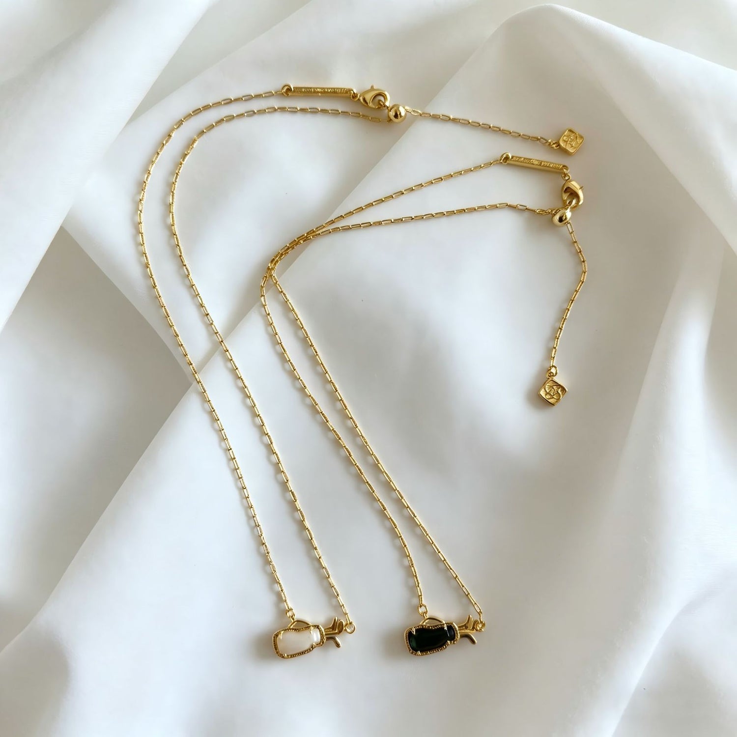 Gold-tone layered charm necklace with multiple thin chains and small heart pendants