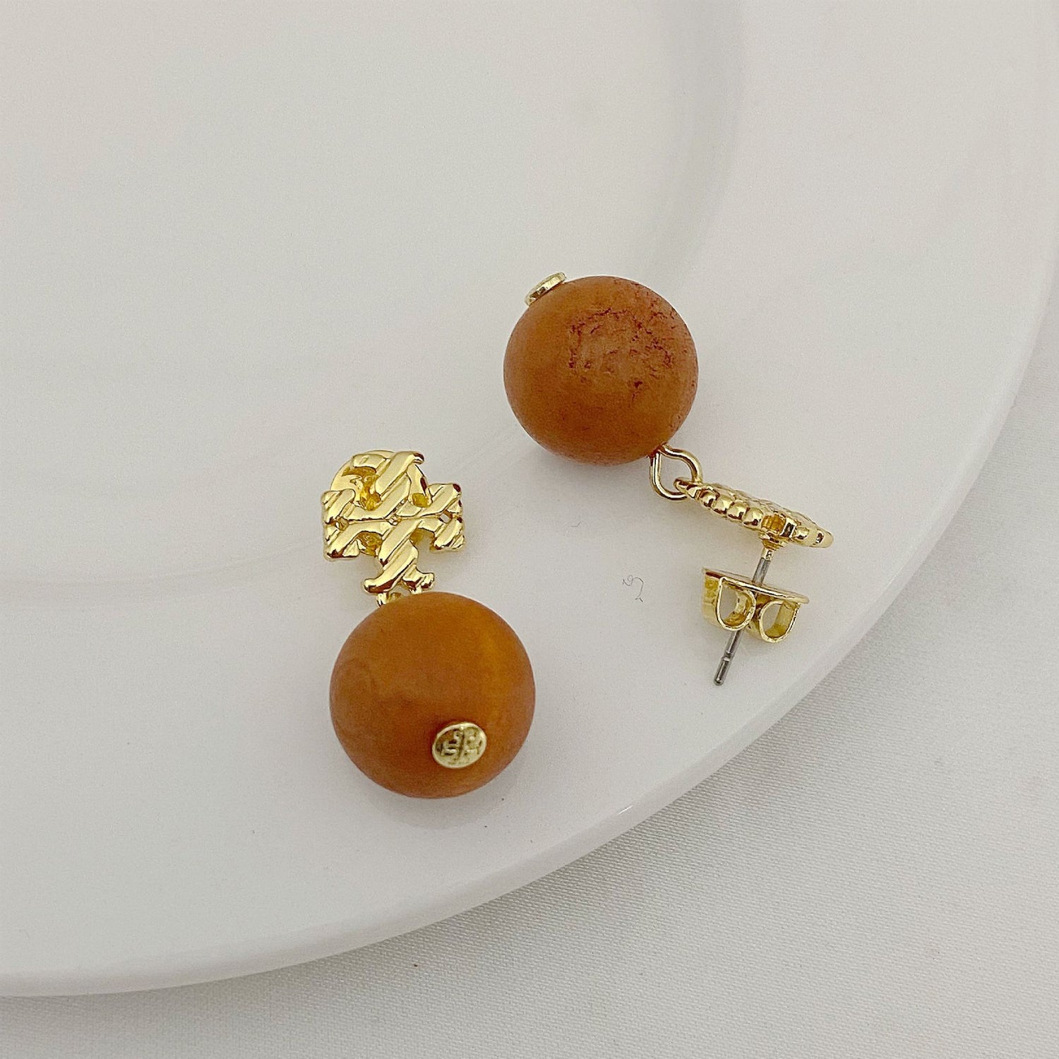 Striped logo beaded pendant earrings, gold-tone with round red-amber beads