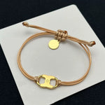 Pulsera con cordón beige ajustable y dije esmaltado amarillo con aro dorado