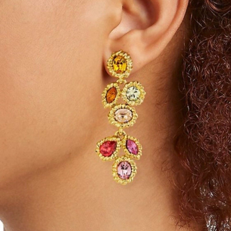 Long vintage crystal earrings with multi-colored stones; worn view on ear