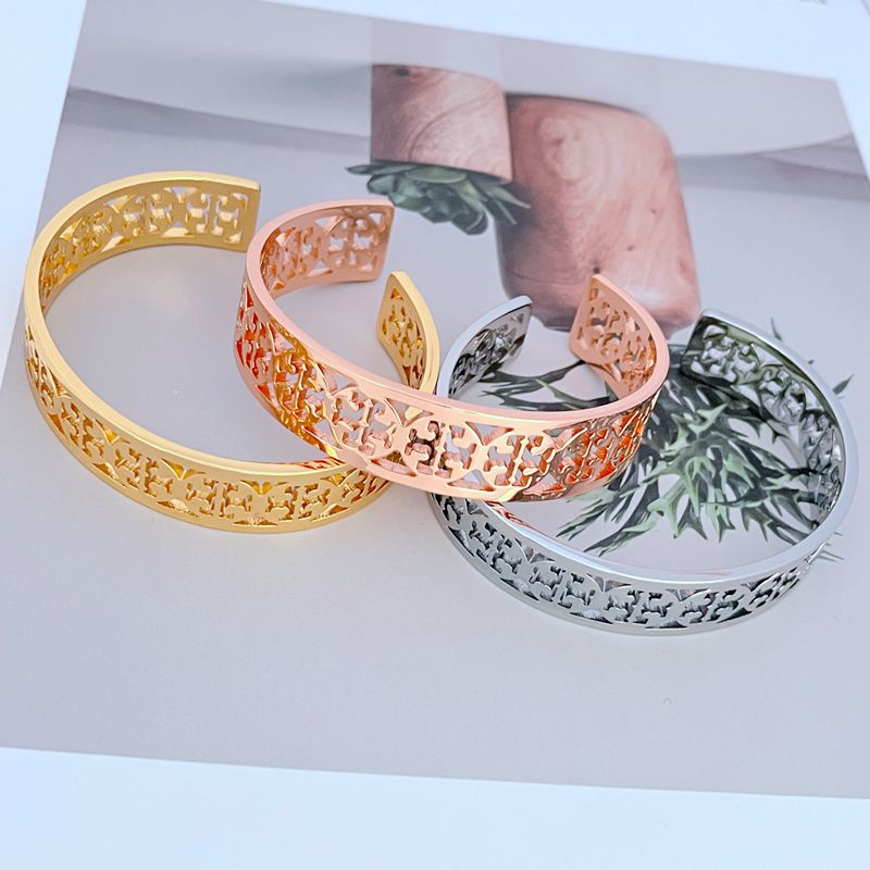 Offene Logo-Armreifen in Gold, Roségold und silberfarben mit durchbrochenem Muster
