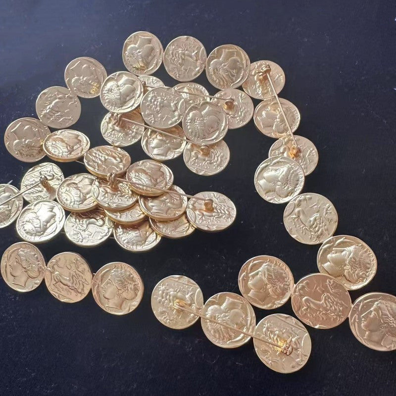 Ancient coin brooch with multiple matte gold coin discs linked in a curved chain