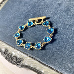 Blue crystal heart link bracelet with gold-tone clasp and heart-shaped stones