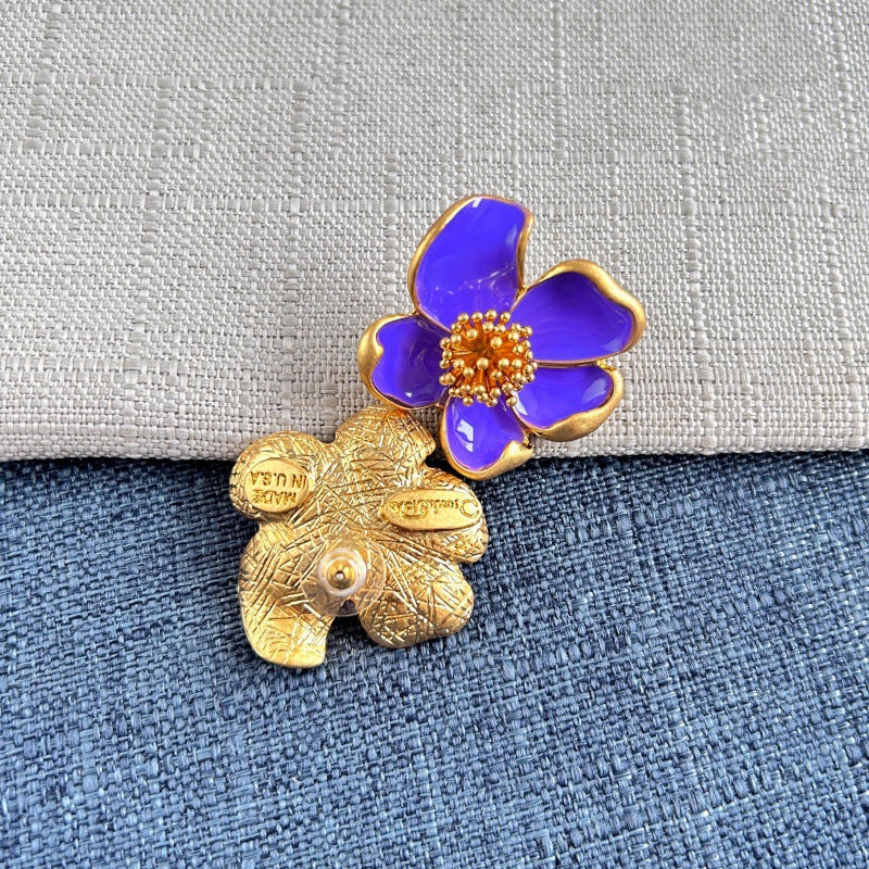 Purple enamel floral stud earrings with gold-tone petals and golden beaded center