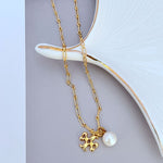 Gold metal necklace with logo flower pendant and white pearl drop