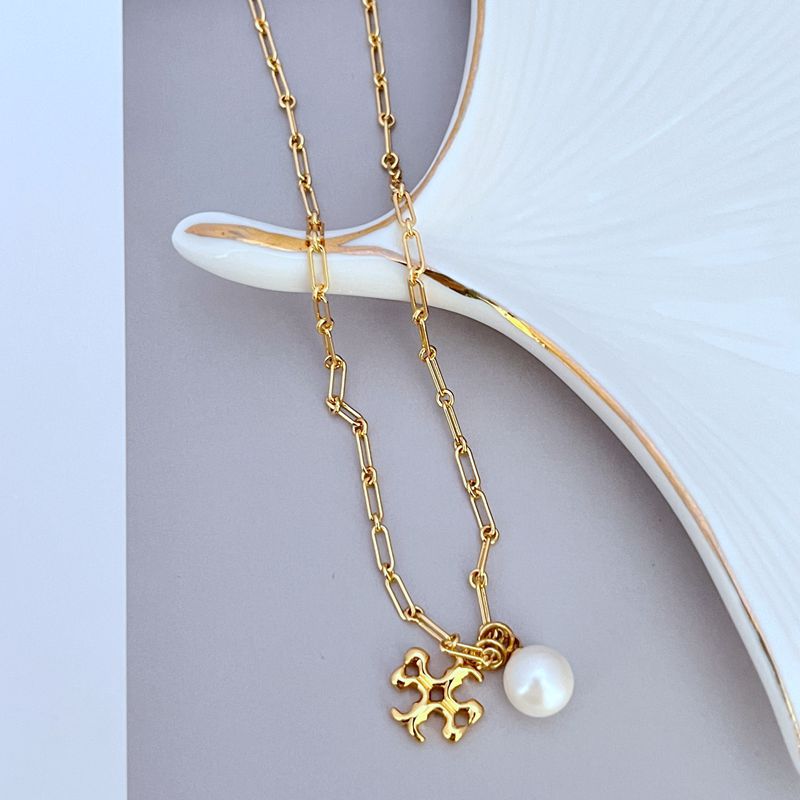 Gold metal necklace with logo flower pendant and white pearl drop