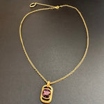 Gold-tone square pendant necklace with hammered texture and pink faceted stone