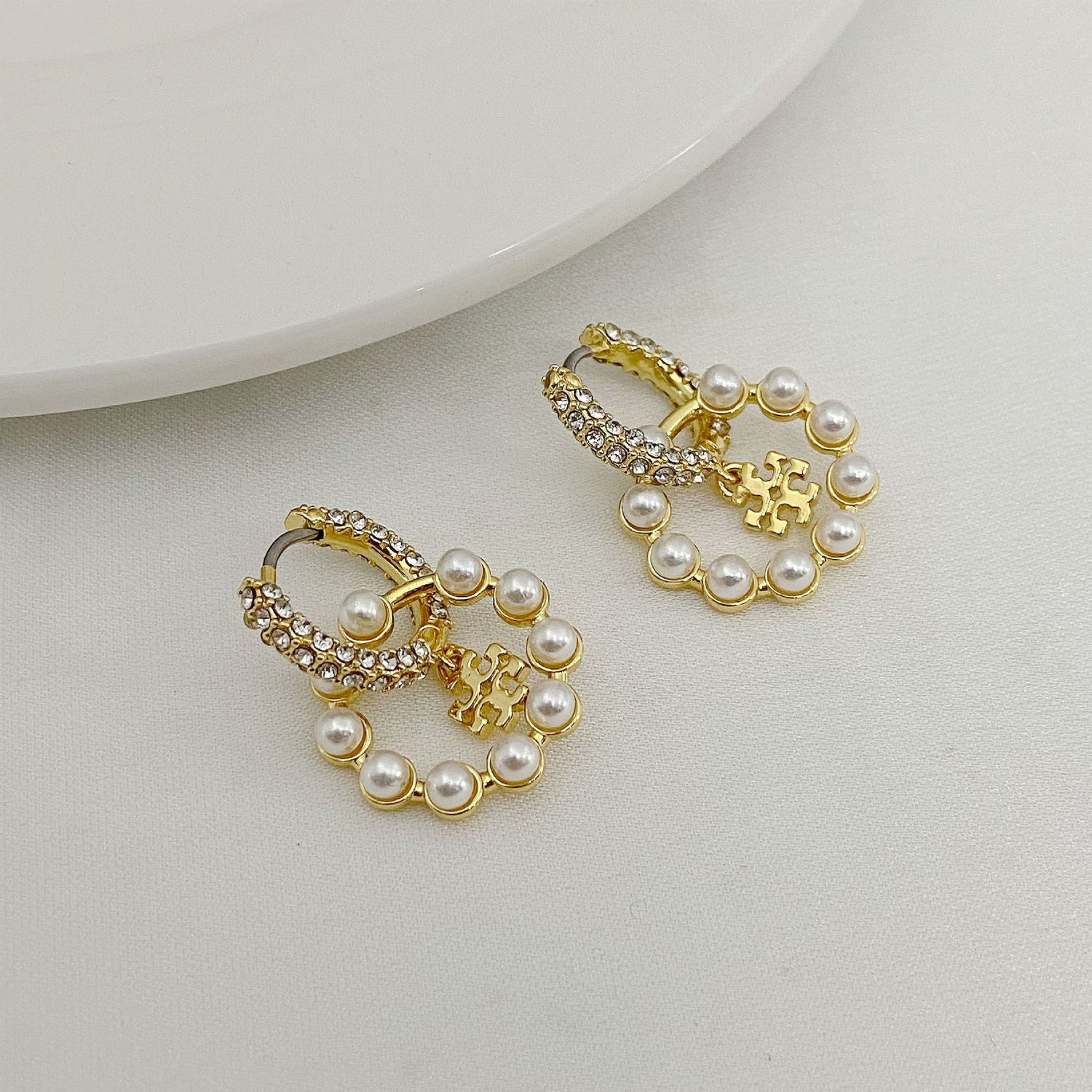 Gold-tone hoop pendant earrings with rhinestones and white pearl drops