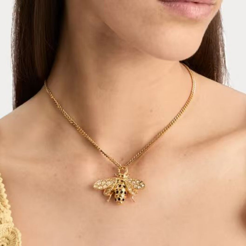 Gold chain necklace with crystal bee pendant at the collar