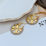 Goldfarbene Creolen mit Zirkonia-Rand und offenem Metallgitter im Kreis