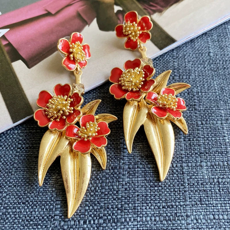 Red floral drop earrings with gold-tone spear drops and red enamel blossoms