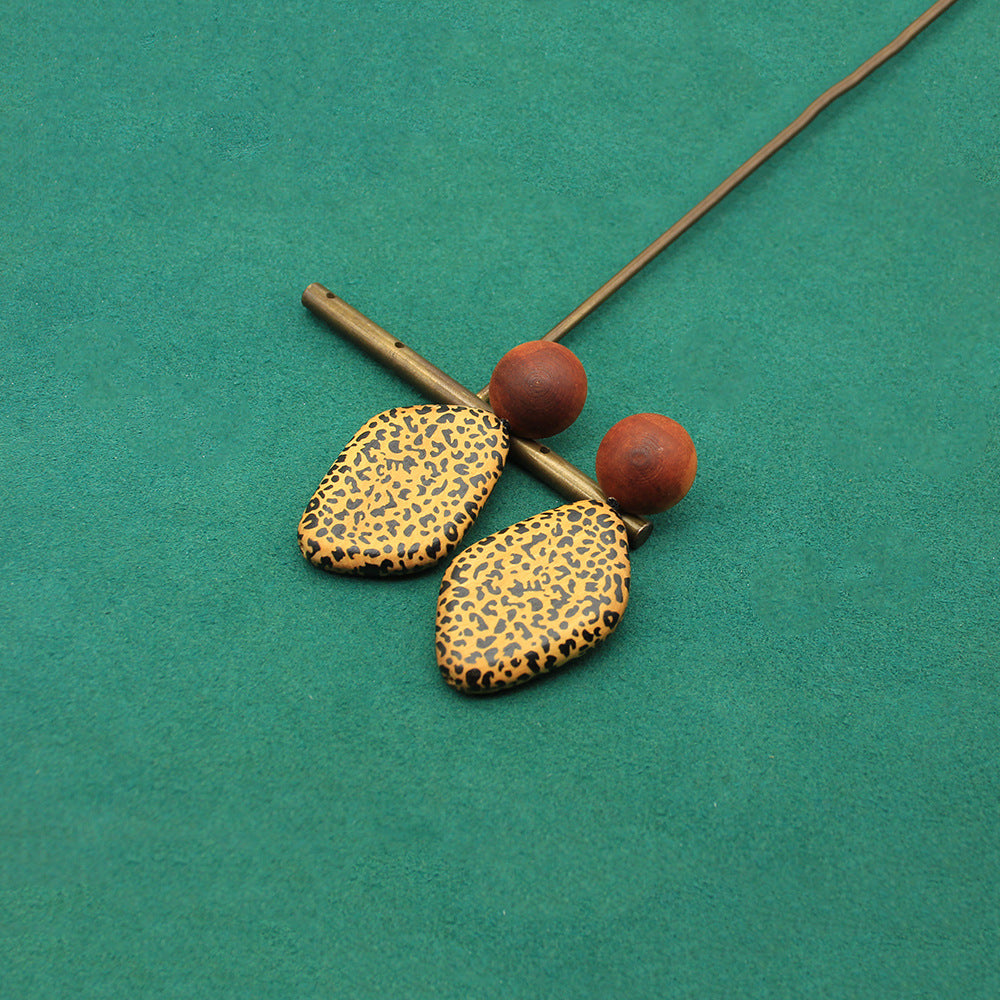 Wooden heart-shaped earrings with leopard-pattern faces and brown spherical tops