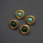 Gold-tone oval stud earrings with green cabochon centers and rhinestone detail