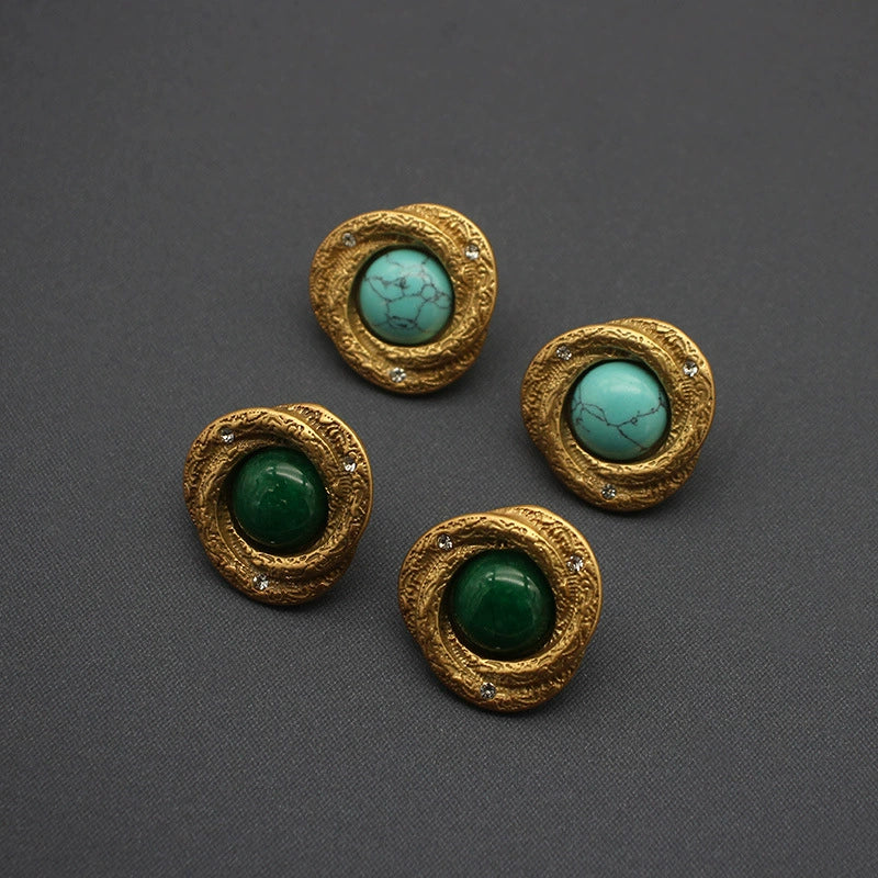 Gold-tone oval stud earrings with green cabochon centers and rhinestone detail