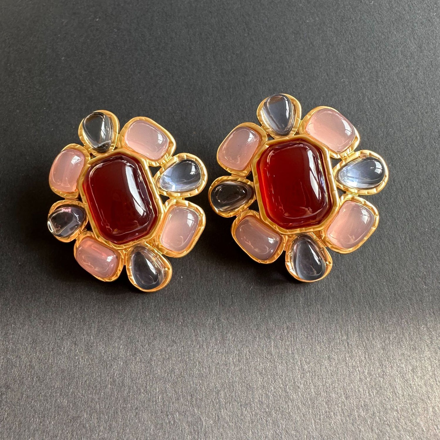 Vintage-style irregular crystal stud earrings with red center and pink, dark gray stones, gold-tone
