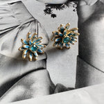Enamel flower earrings with gold-tone petals and blue center stones, dangle drop studs