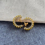 Gold-tone cubic zirconia C-hoop earrings with yellow and clear stones, front view