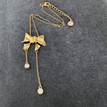 Bow crystal tassel necklace, gold-tone with bow pendant and three round crystal drops