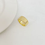 Gold metal ring with ribbed striped front and small rhinestone accents