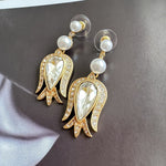 Gold-tone tulip earrings with clear pear crystal centers, pearl beads, and sparkling border details