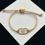 Pulsera ajustable con cordón marrón y dije esmaltado rosa con herrajes dorados