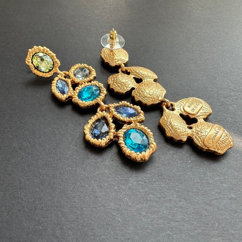 Blue crystal drop earrings with gold-tone butterfly backs and teardrop stones