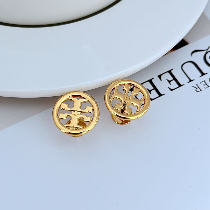 Gold-tone round logo stud earrings, close-up of the openwork emblem