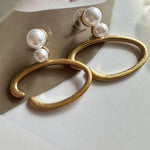 O-ring pearl earrings, gold-tone hoops with two white pearls, side view