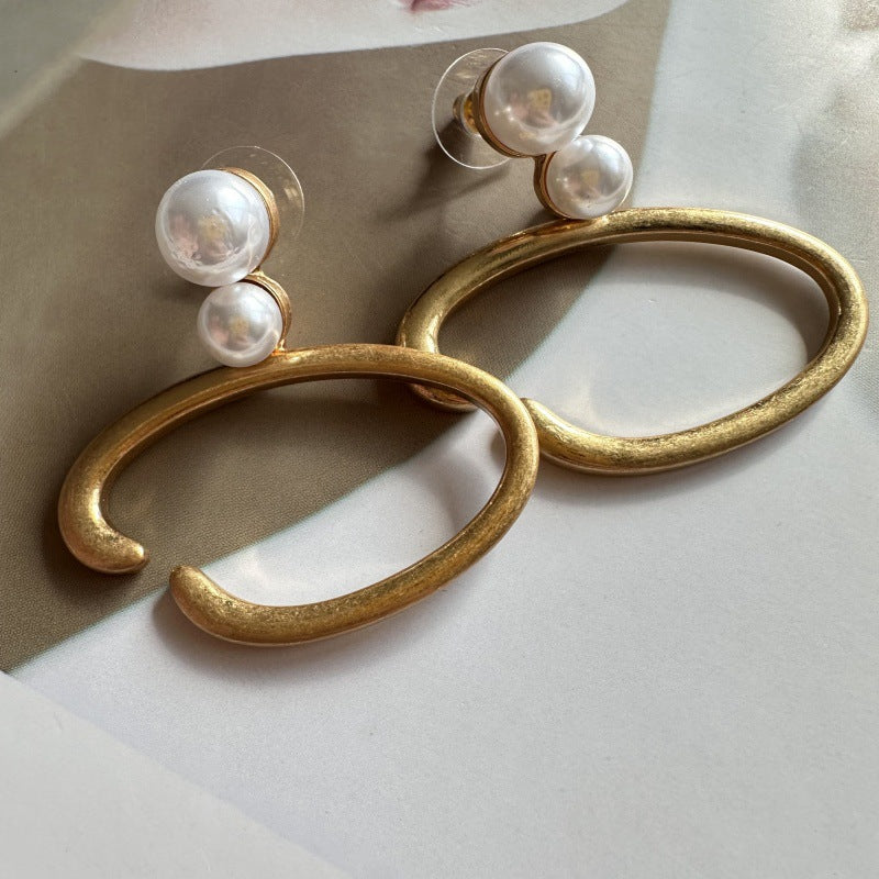 O-ring pearl earrings, gold-tone hoops with two white pearls, side view