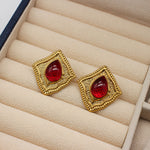 Vintage square stud earrings with red glass-like gemstone inserts in gold-tone frames