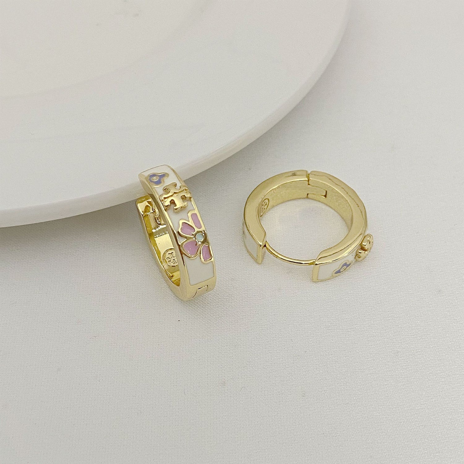Gold enamel flower hoop earring with open back and purple flower details